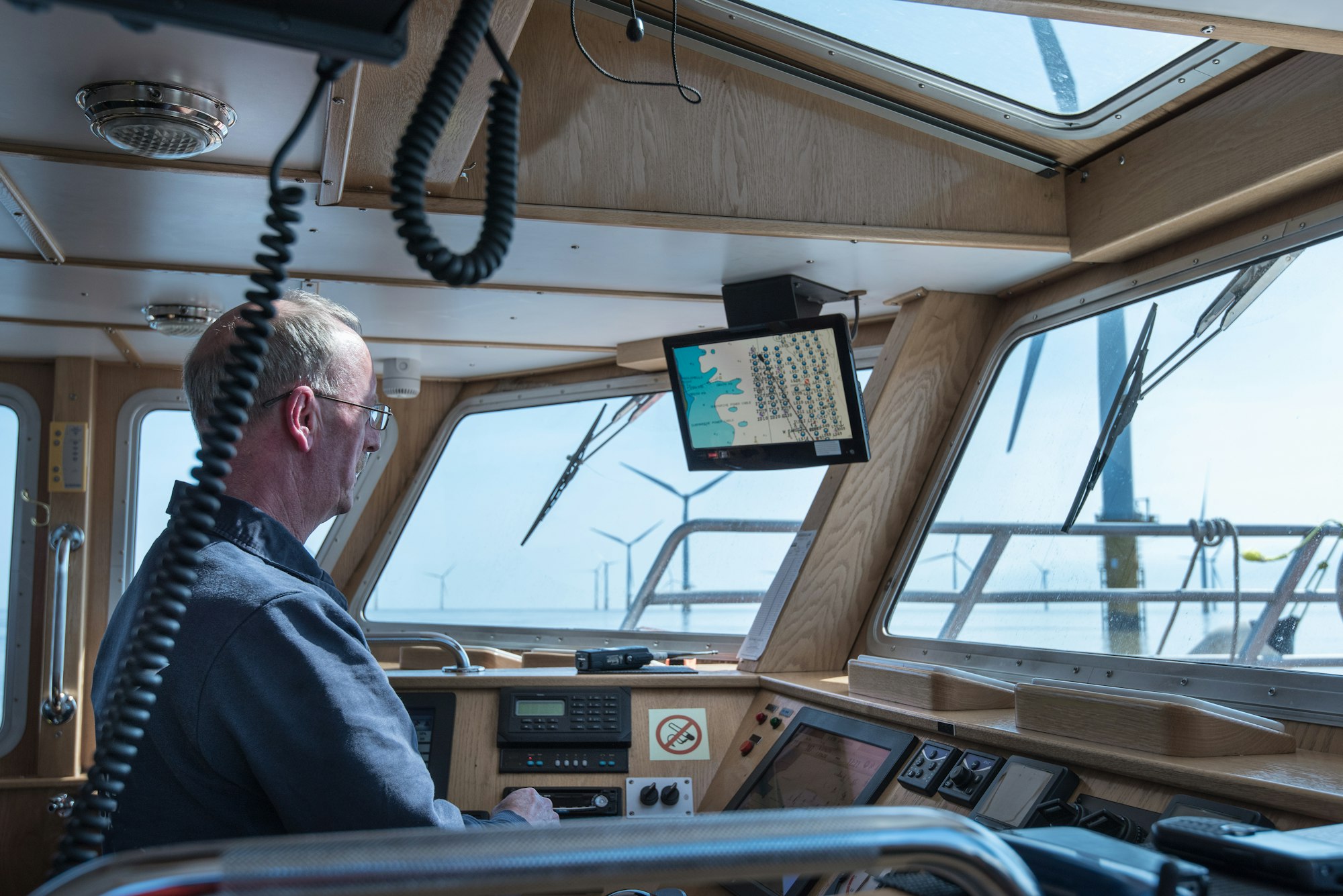 Captain steering service boat at offshore windfarm